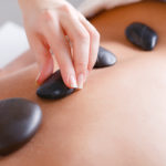 Woman enjoying a hot stone massage at the health club spa