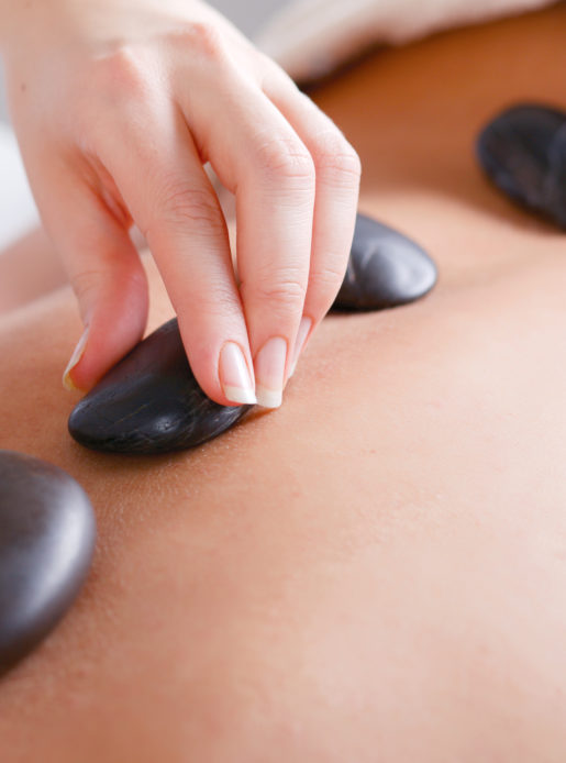 Woman enjoying a hot stone massage at the health club spa