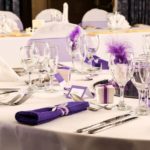 Table dressed with purple themed place settings for a wedding at mercure hotels