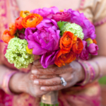 An indian bride holding a beautiful bouquet of colourful flowers