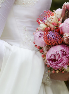 bride in a white dress holding a colourful bouquet