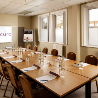 Table and chairs ready for a meeting in the county room at Mercure Maidstone Great Danes Hotel