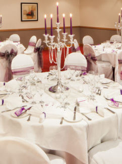 Tables set for a purple wedding breakfast in Park View at Mercure Maidstone Great Danes Hotel