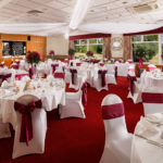 Tables set in red for a wedding breakfast at Mercure Maidstone Great Danes Hotel