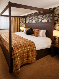 A superior room with four poster bed and lakeside view at Mercure Maidstone Great Danes Hotel