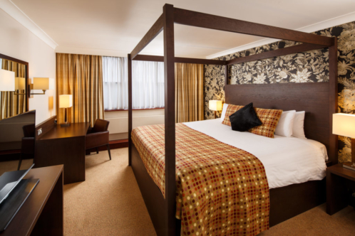 A superior room with four poster bed and lakeside view at Mercure Maidstone Great Danes Hotel