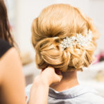 Portrait of attractive young woman with beautiful hairstyle and stylish hair accessory, rear view